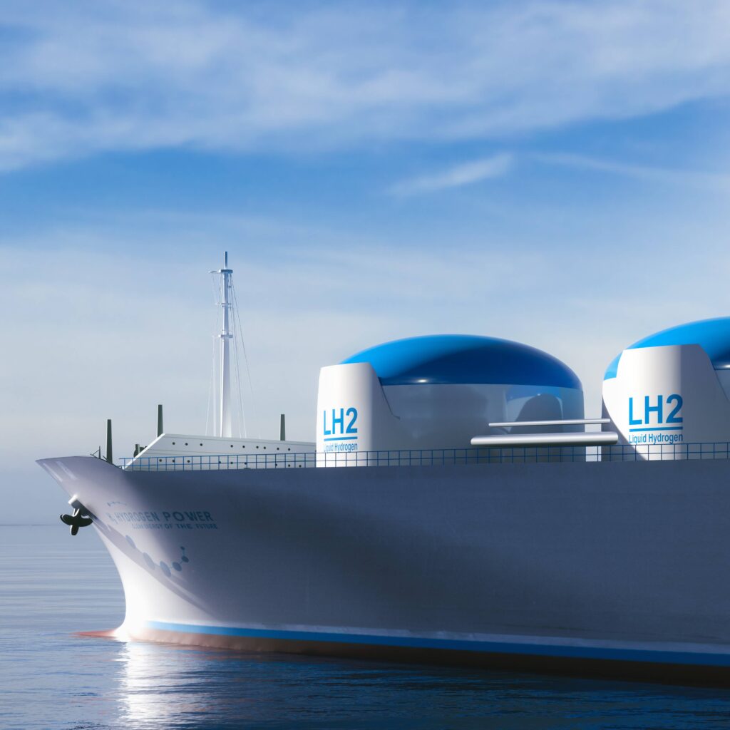 Ein großes Schiff transportiert Flüssigwasserstoff (LH2) auf ruhiger See unter blauem Himmel.